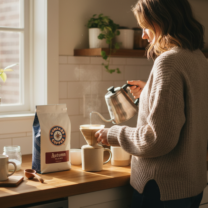 Woman making coffee using a pour-over method in a kitchen.