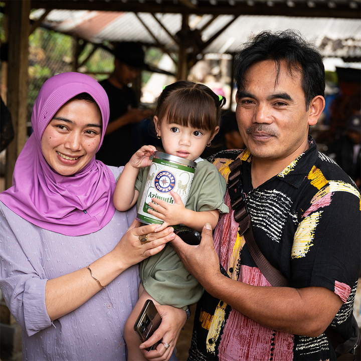 Family holding a container with a brand logo, standing outdoors.